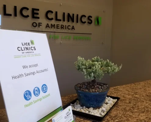 Inside receptionist desk at lice clinics midsouth with a sign that says they accept health savings accounts